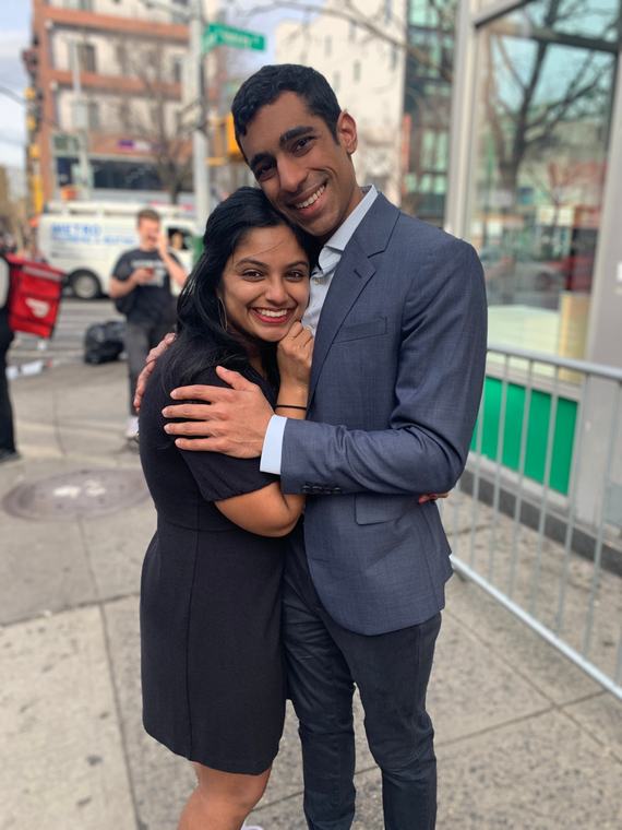 Manu and Nikhil hugging on a New York sidewalk